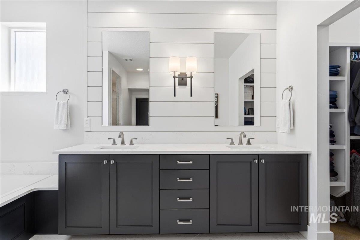 3794 South Single Tree Avenue Boise, ID 83716 - Photo 29 of 50 Double vanity with dark shaker-style cabinetry, white countertops, and dual undermount sinks
