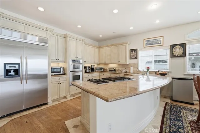 a kitchen with stainless steel appliances granite countertop a stove a sink and a refrigerator
