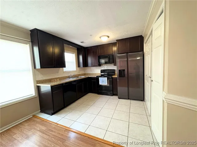 a kitchen with stainless steel appliances granite countertop a refrigerator and a stove top oven
