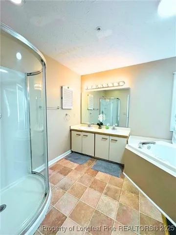 a bathroom with a tub sink shower and mirror
