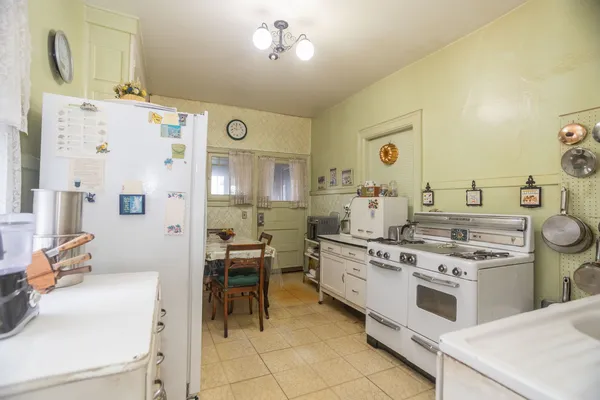 a kitchen with a stove and chairs
