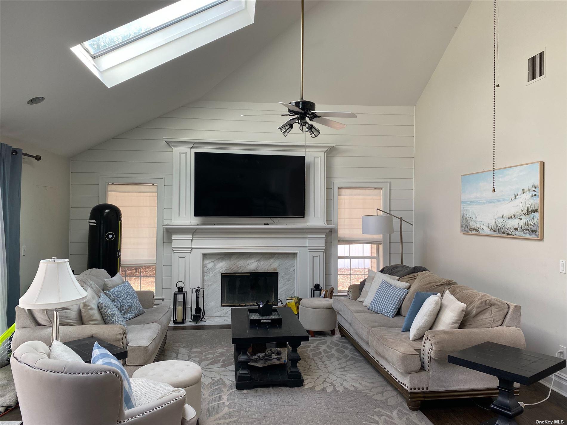 22 Drew Drive Eastport, NY 11941 - Photo 3 of 8 a living room with furniture a fireplace and a flat screen tv