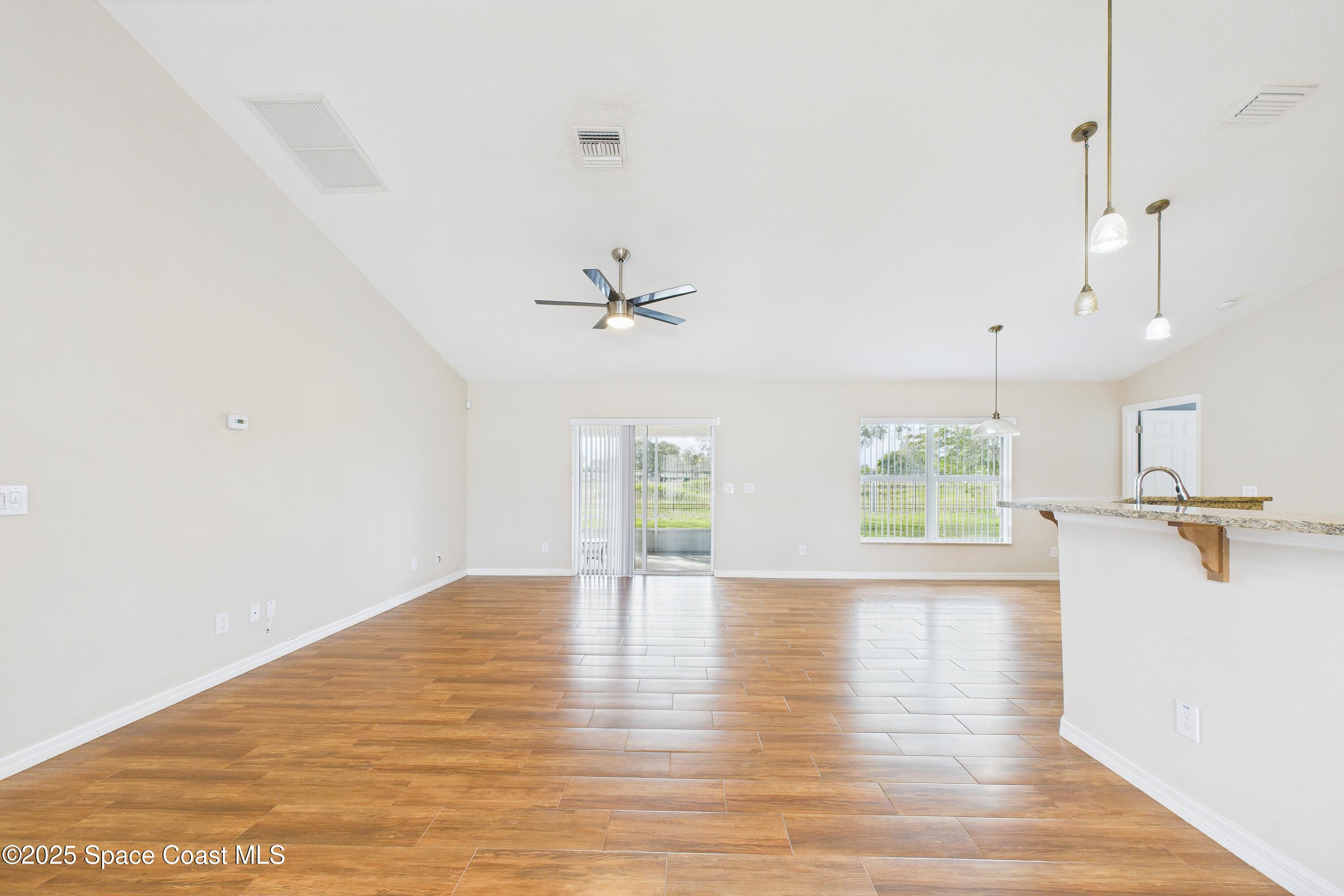 1936 Gloria Circle Palm Bay, FL 32905 - Photo 11 of 50 a view of an empty room with wooden floor and a window