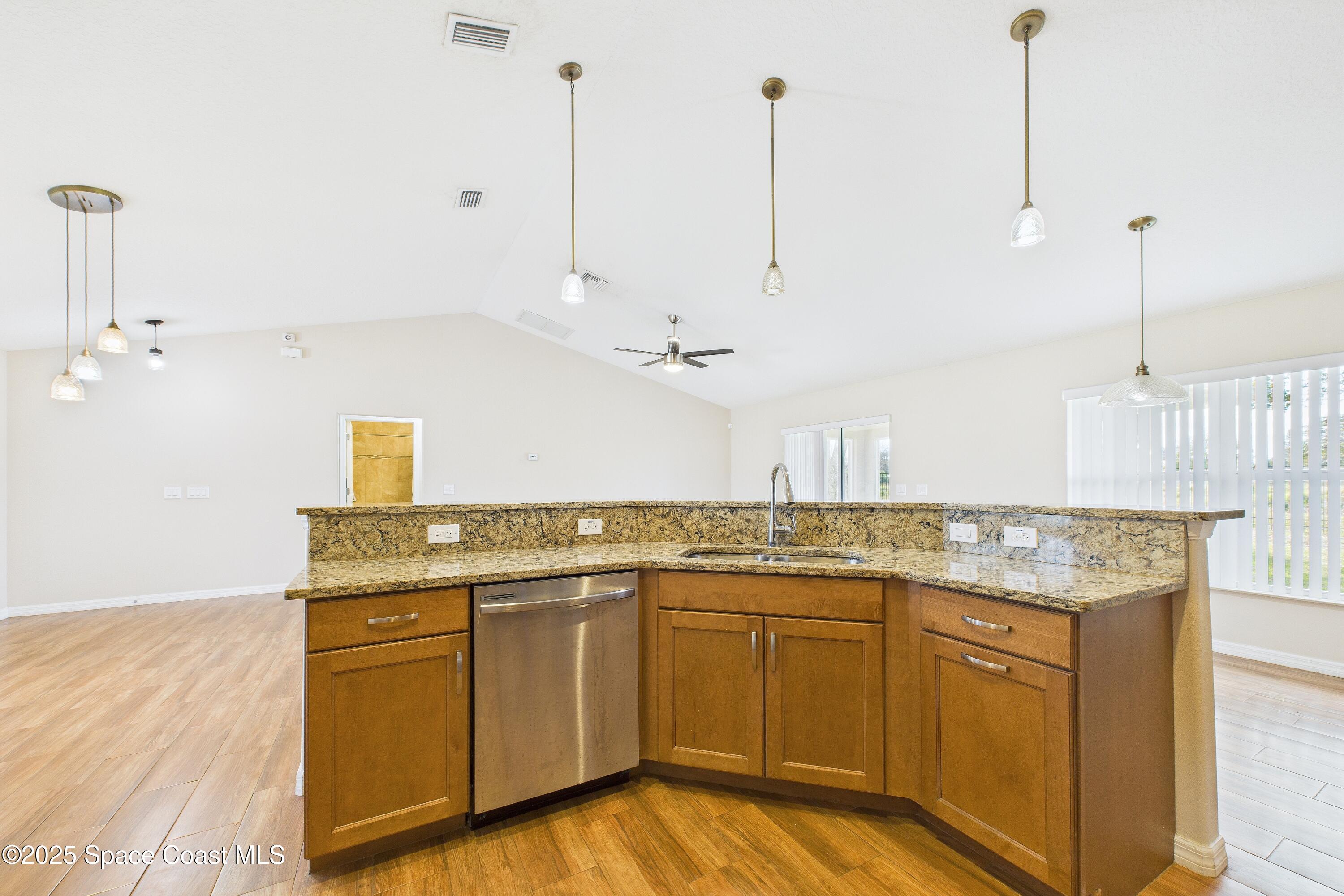 1936 Gloria Circle Palm Bay, FL 32905 - Photo 12 of 50 a kitchen with kitchen island granite countertop a sink a counter space appliances and cabinets