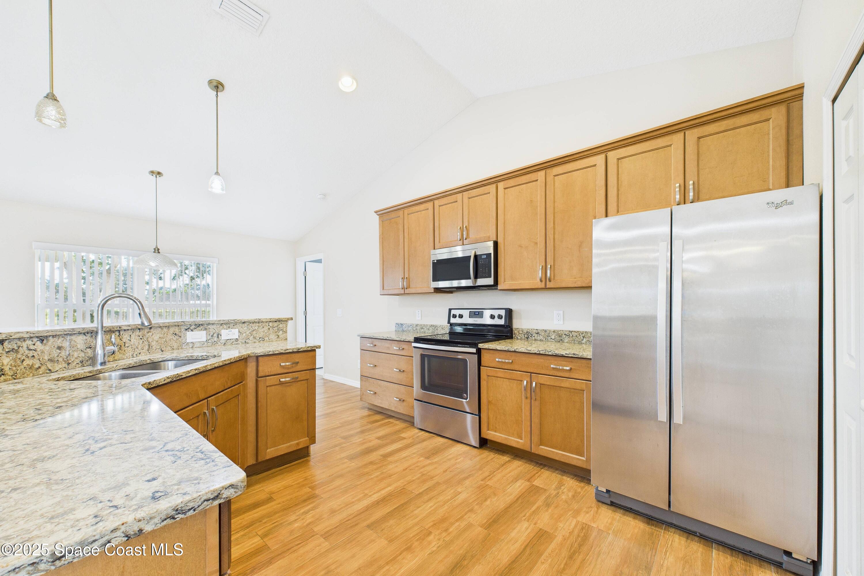 1936 Gloria Circle Palm Bay, FL 32905 - Photo 13 of 50 a kitchen with stainless steel appliances granite countertop a sink refrigerator and cabinets