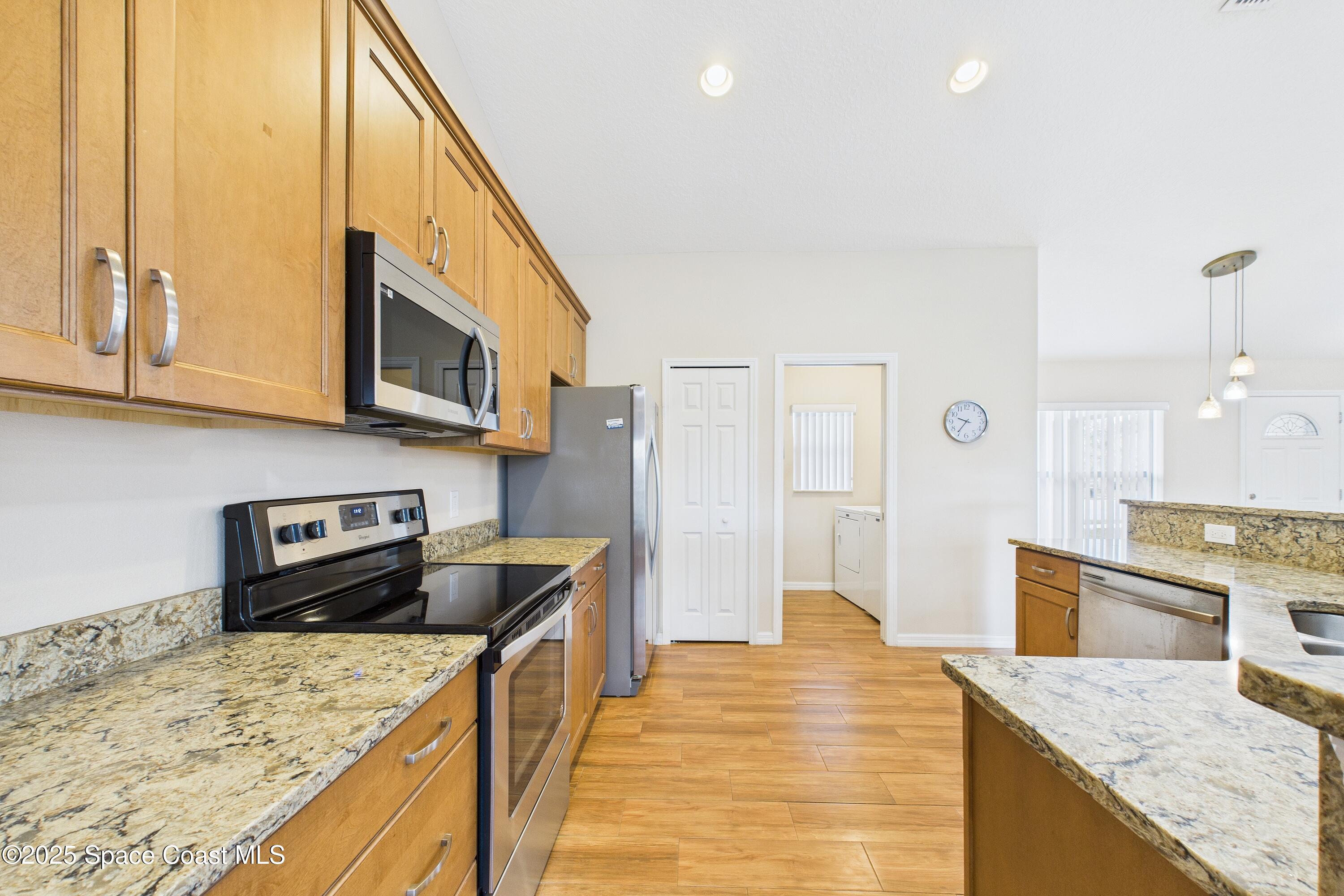 1936 Gloria Circle Palm Bay, FL 32905 - Photo 15 of 50 a kitchen with stainless steel appliances granite countertop a sink stove and refrigerator