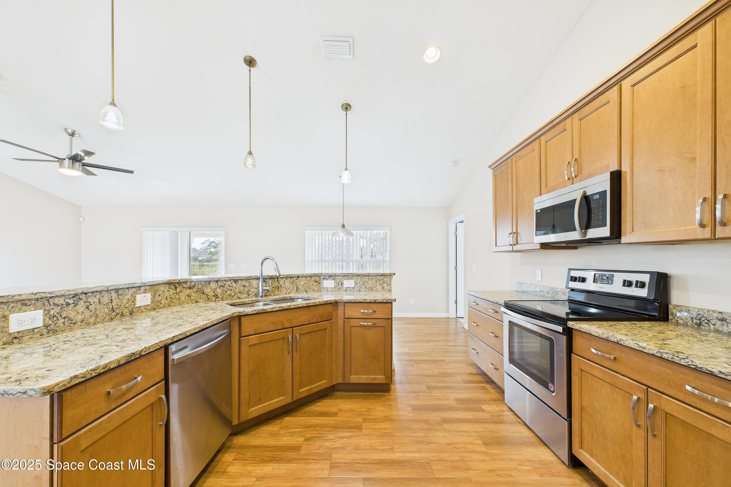 1936 Gloria Circle Palm Bay, FL 32905 - Photo 17 of 50 a kitchen with stainless steel appliances granite countertop a sink a stove top oven a counter space and cabinets