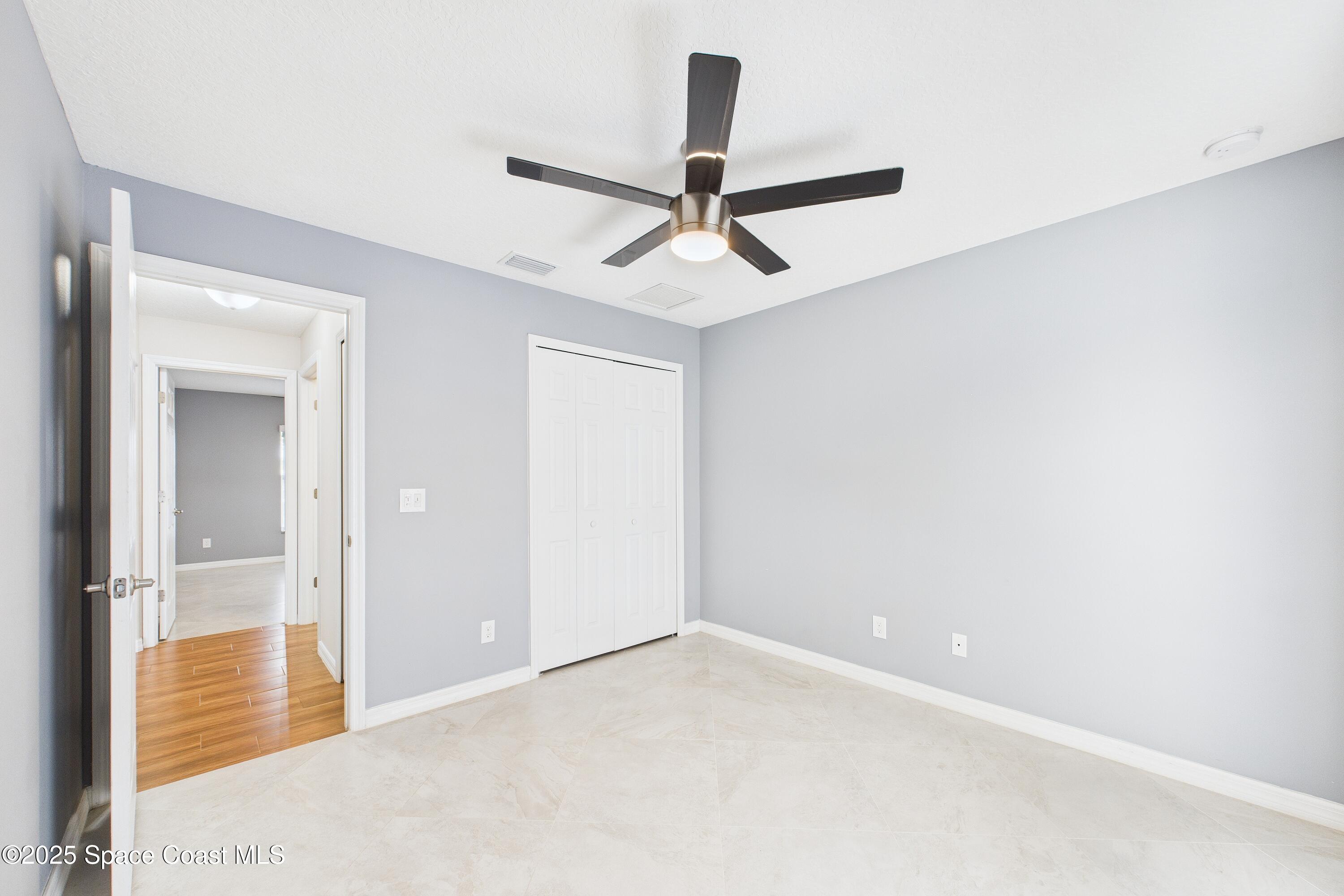 1936 Gloria Circle Palm Bay, FL 32905 - Photo 20 of 50 an empty room with closet and a chandelier fan