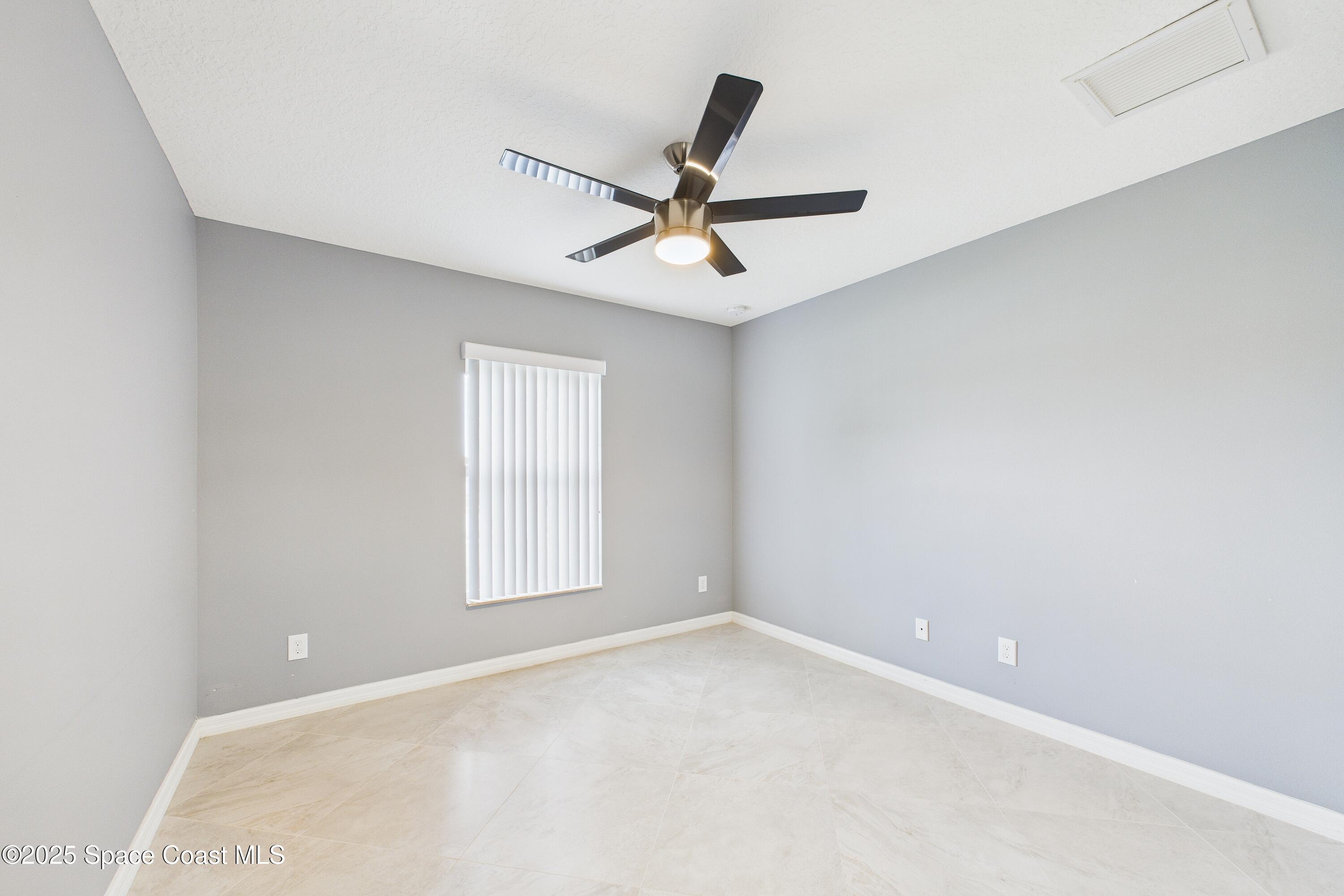 1936 Gloria Circle Palm Bay, FL 32905 - Photo 22 of 50 a view of a ceiling fan and a window in the room