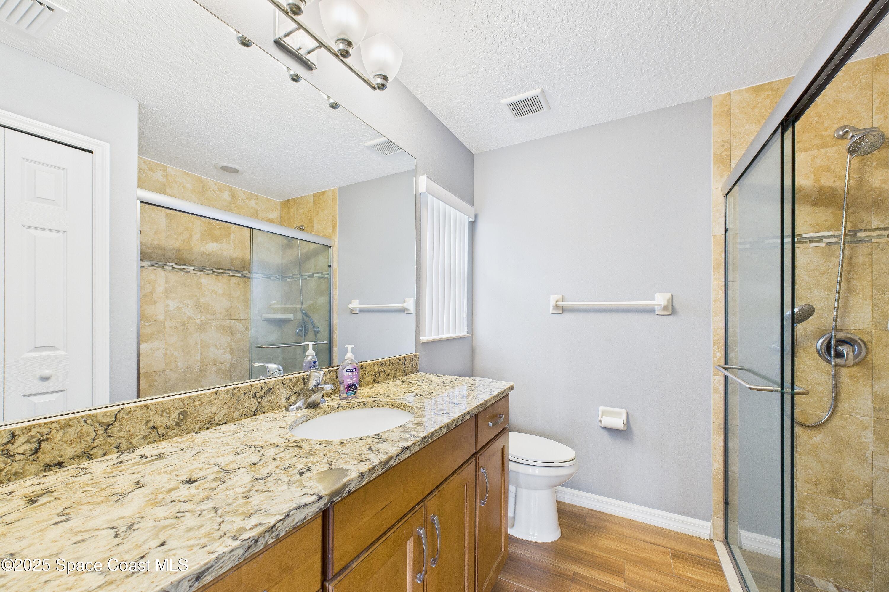 1936 Gloria Circle Palm Bay, FL 32905 - Photo 31 of 50 a bathroom with a granite countertop sink toilet and shower