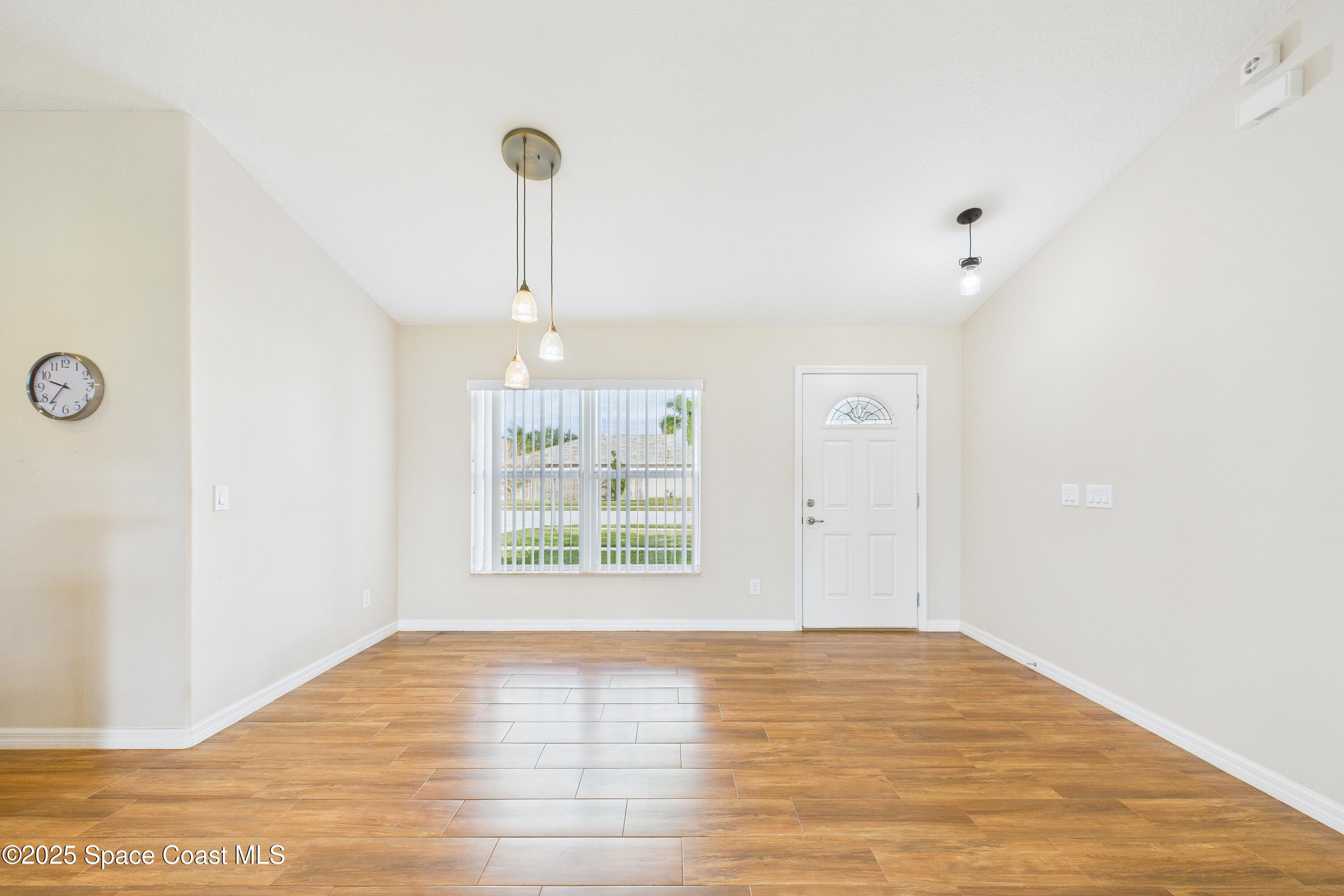 1936 Gloria Circle Palm Bay, FL 32905 - Photo 34 of 50 a view of an empty room with wooden floor and a window