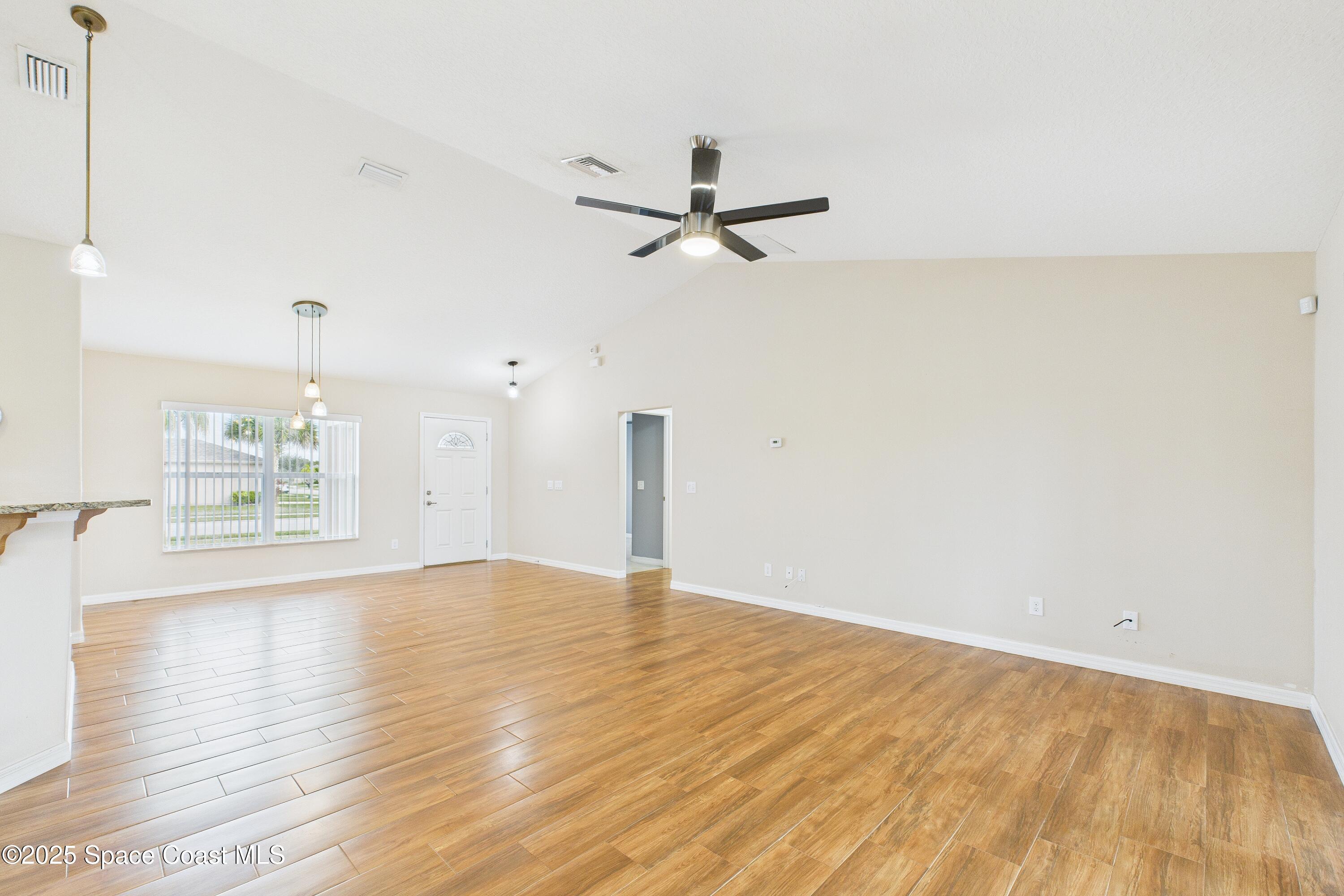 1936 Gloria Circle Palm Bay, FL 32905 - Photo 6 of 50 a view of empty room with wooden floor and ceiling fan