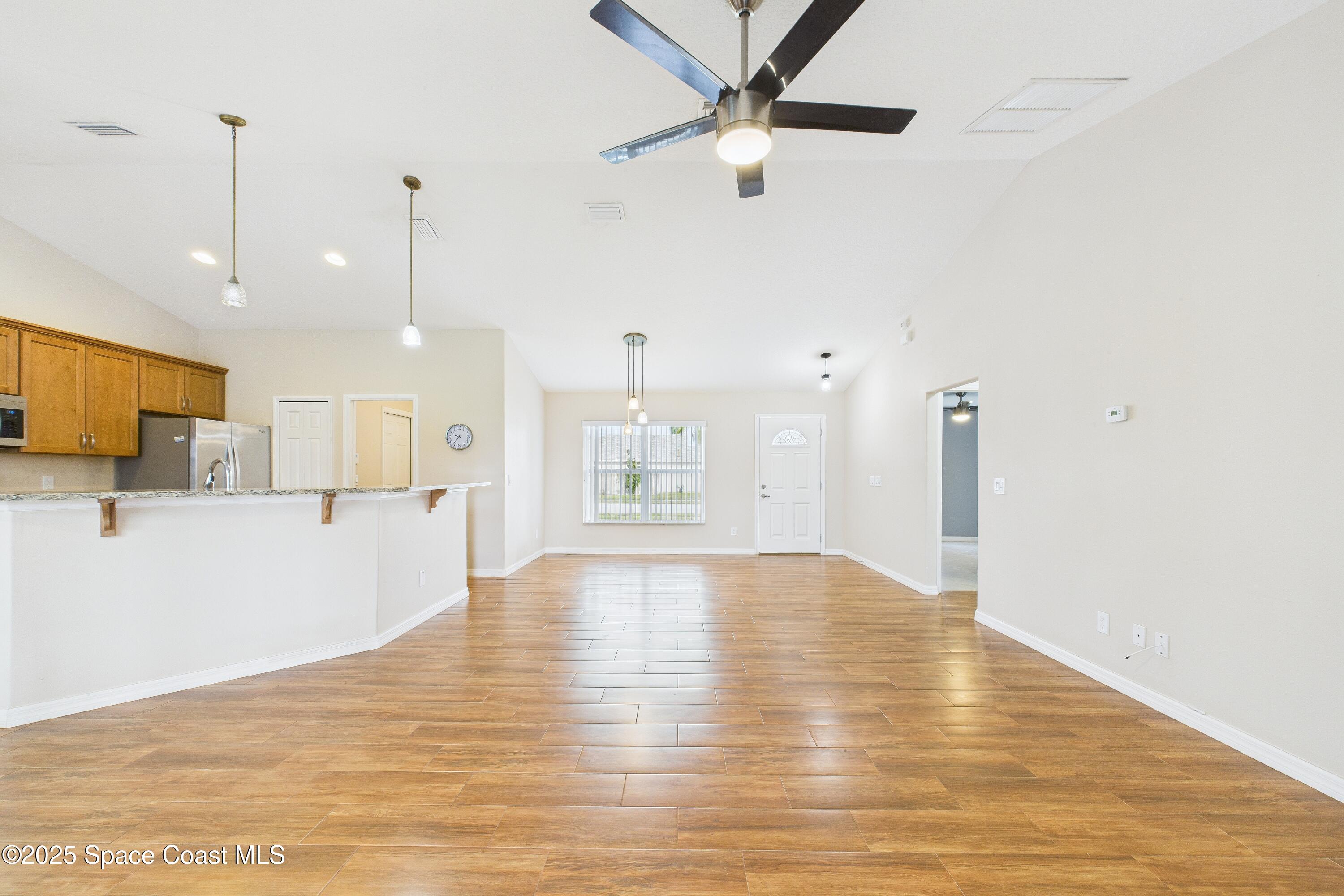 1936 Gloria Circle Palm Bay, FL 32905 - Photo 8 of 50 a view of an empty room with kitchen appliances and a ceiling fan