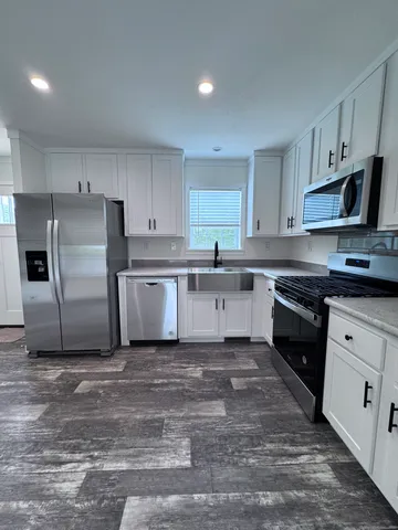 a kitchen with a sink a stove a refrigerator and cabinets