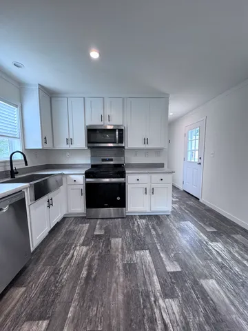 a kitchen with granite countertop a sink and cabinets