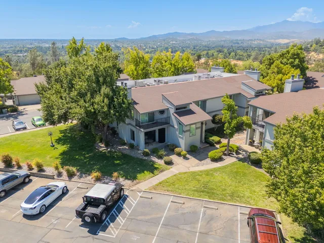 an aerial view of a house with a garden and lake view
