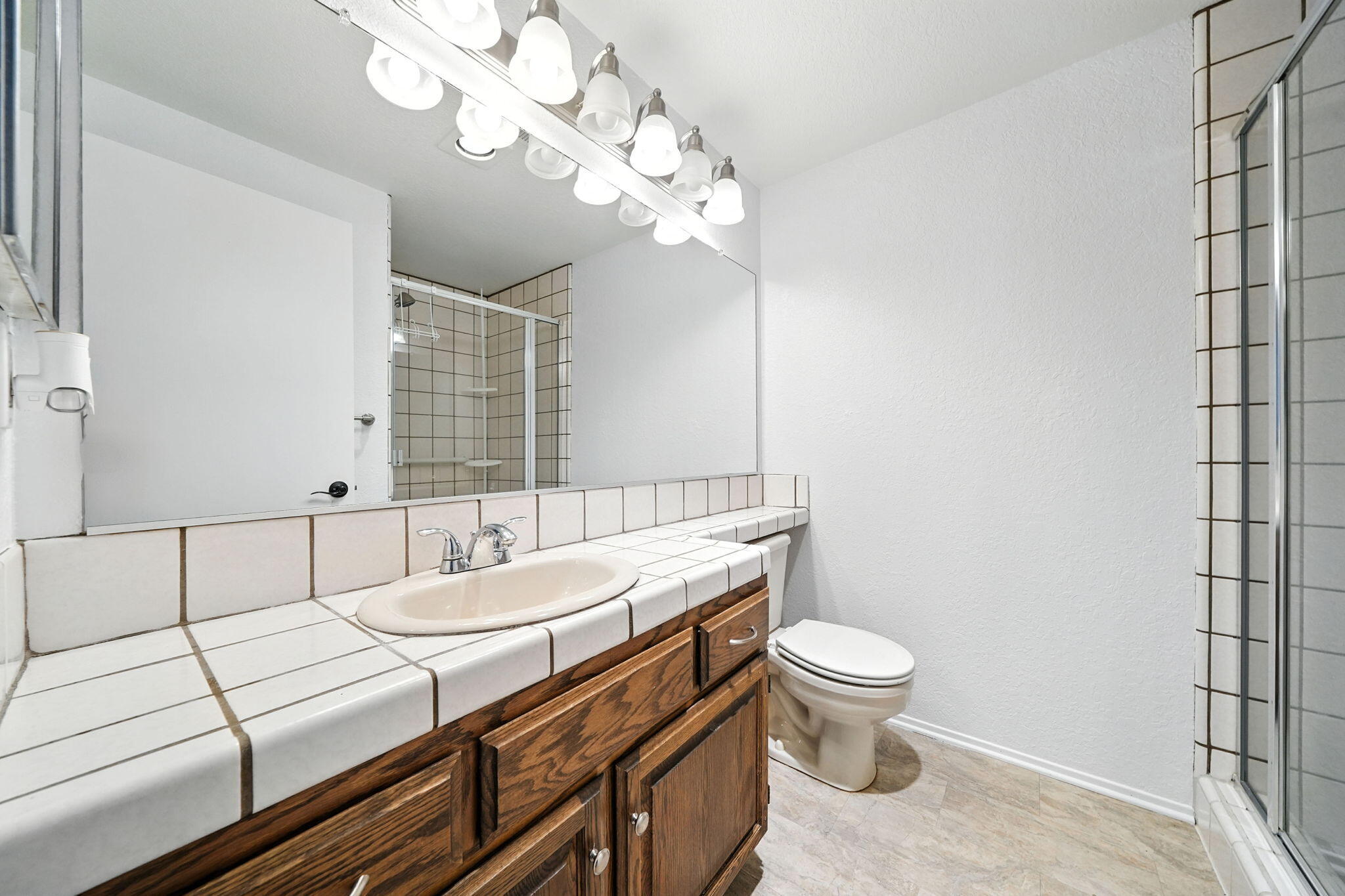 488 Ridgecrest Trail, Unit 133 Redding, CA 96003 - Photo 23 of 30 a bathroom with a sink a toilet a mirror and shower curtain