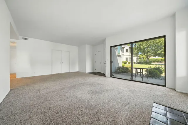 a view of a room that has a large window and dining room
