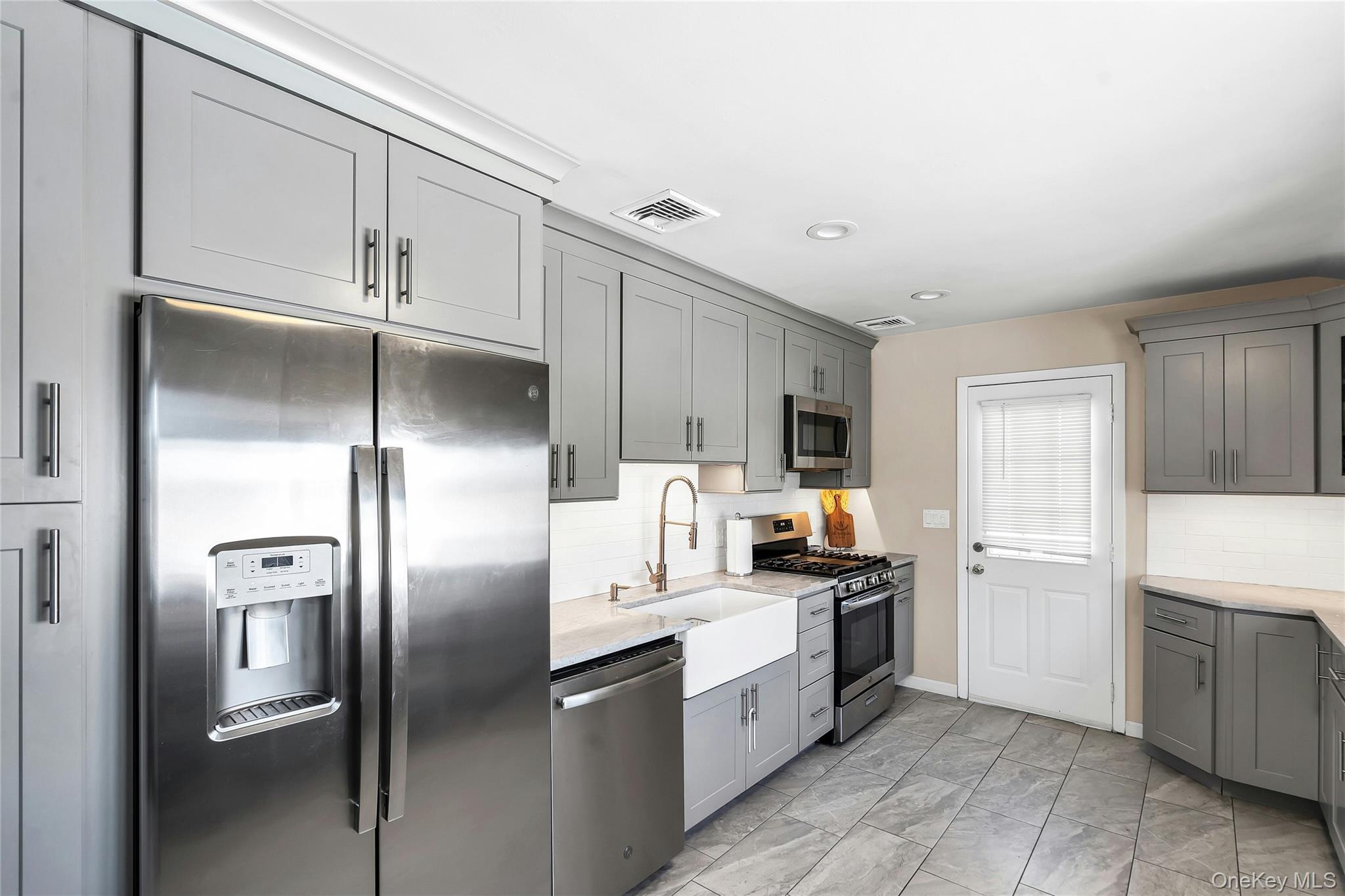 53 Calvert Avenue Commack, NY 11725 - Photo 12 of 25 a kitchen with stainless steel appliances a refrigerator sink and stove