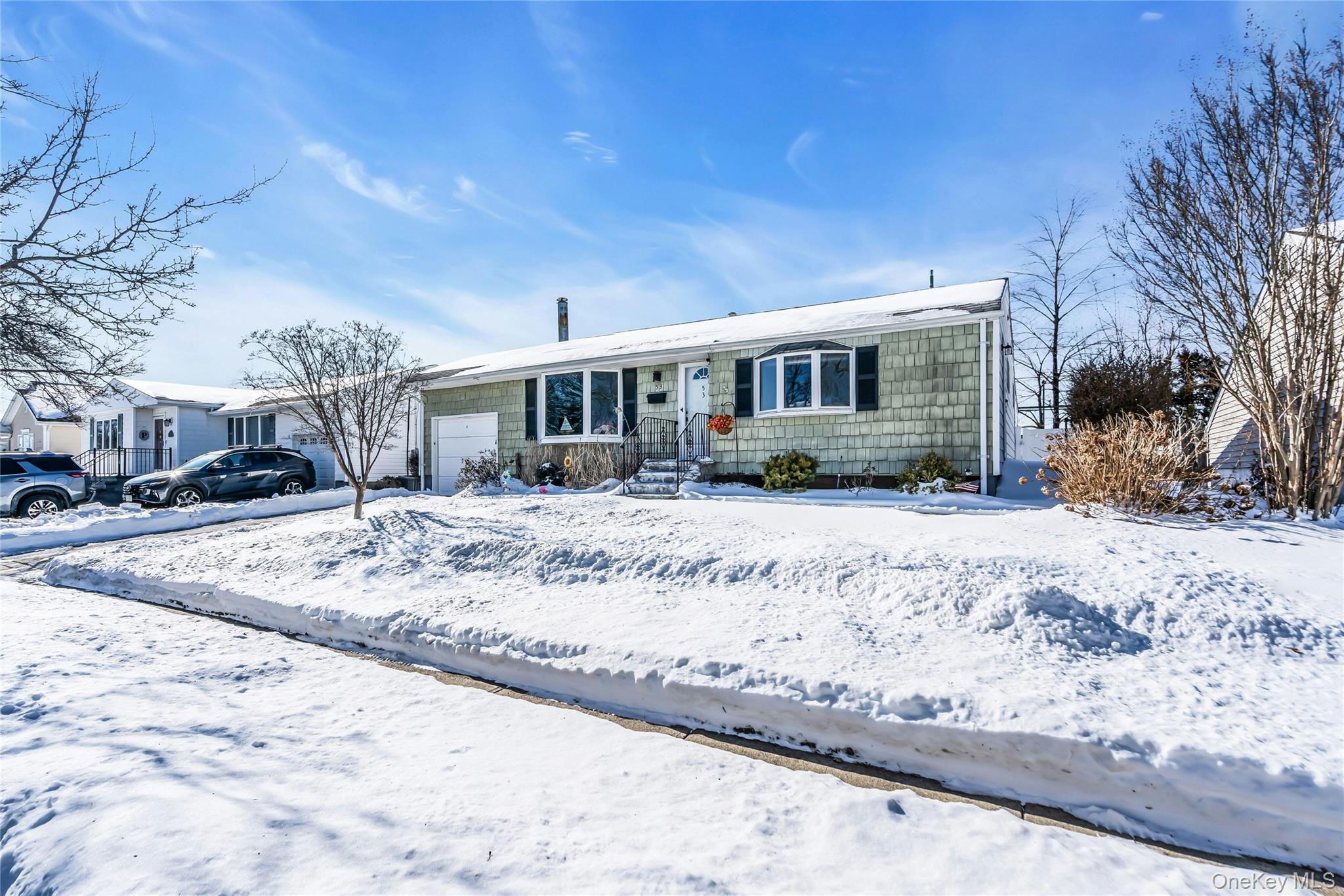 53 Calvert Avenue Commack, NY 11725 - Photo 5 of 25 a front view of a house with a yard covered in snow