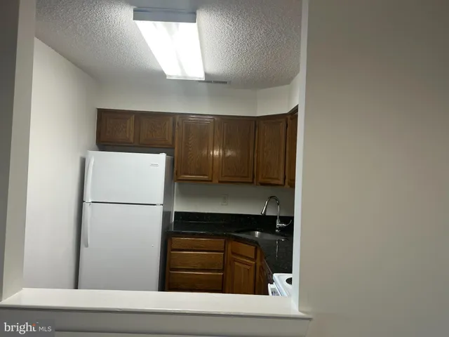 a kitchen with a refrigerator and white cabinets