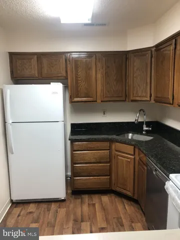 a kitchen with granite countertop cabinets stainless steel appliances and a sink