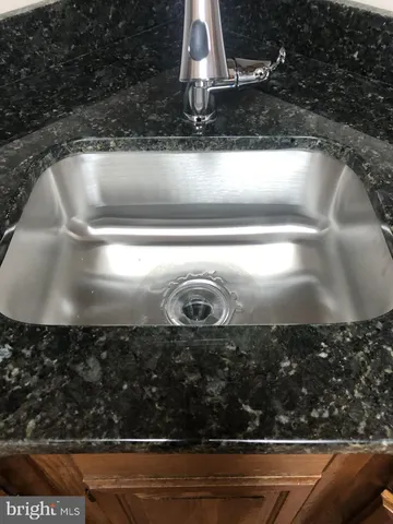 a kitchen with granite countertop cabinets stainless steel appliances and a sink