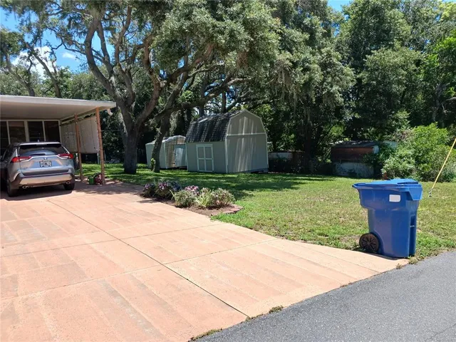 a view of a house with backyard and sitting area