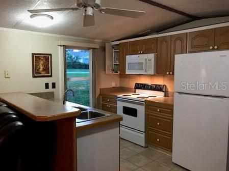 25624 Madison Street Astatula, FL 34705 - Photo 9 of 20 a kitchen with stainless steel appliances granite countertop a stove and a refrigerator