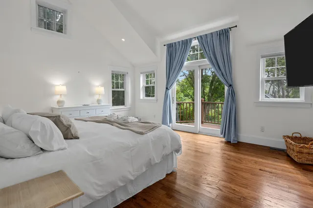 a spacious bedroom with a balcony a bed and a large window