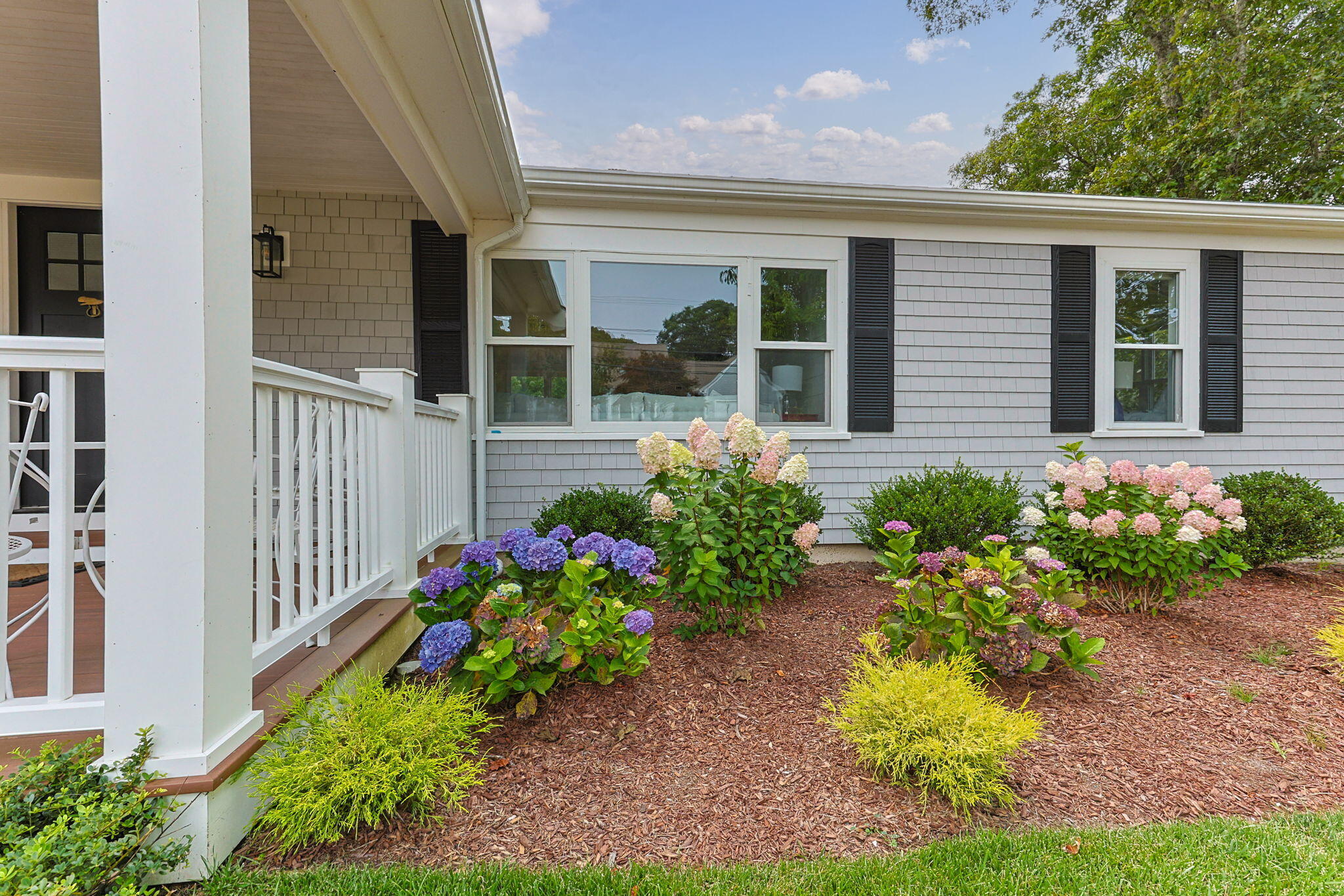 93 Orleans Road Chatham, MA 02633 - Photo 4 of 48 a front view of a house that has a flower garden