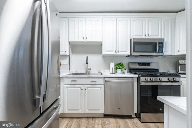 a kitchen with cabinets stainless steel appliances and a counter space