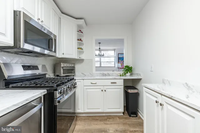 a kitchen with stainless steel appliances granite countertop a sink a stove a microwave and cabinets
