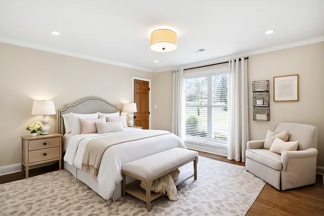 a bedroom with a bed and a dresser with wooden floor
