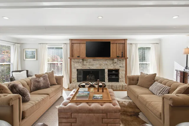 a living room with furniture a flat screen tv and a table