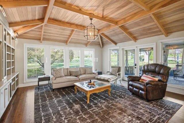 a living room with furniture a chandelier and a dining table