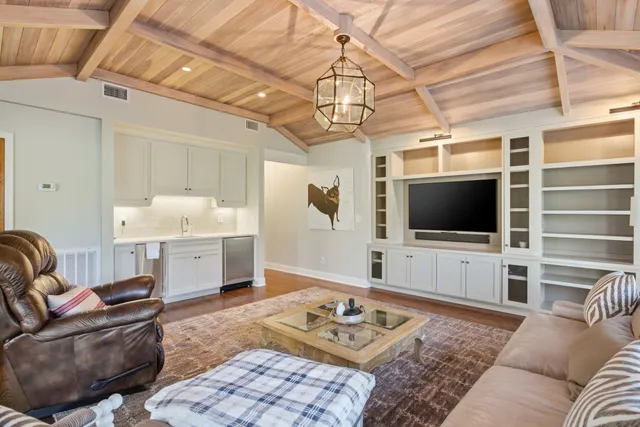 a kitchen with stainless steel appliances granite countertop a table chairs sink and cabinets