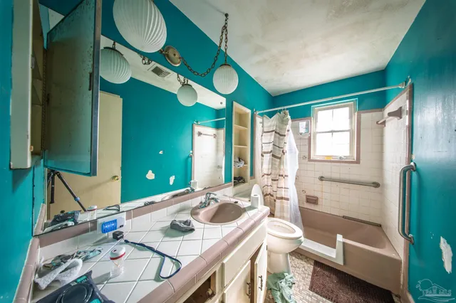 a bathroom with a sink a mirror a toilet and a shower