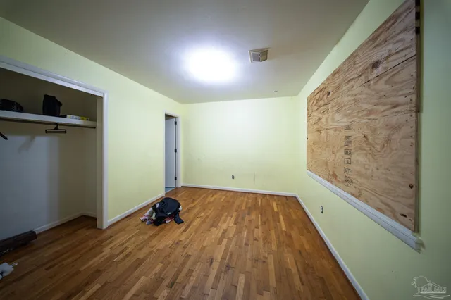 a view of a room with wooden floor and a window
