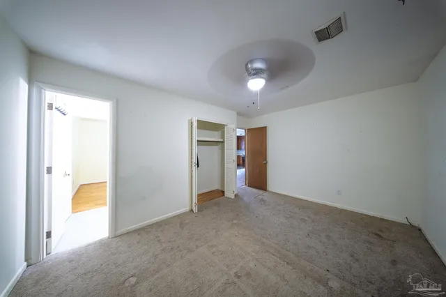 an empty room with a bathroom and mirror