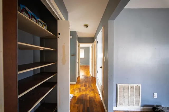 a view of a hallway with wooden floor and staircase