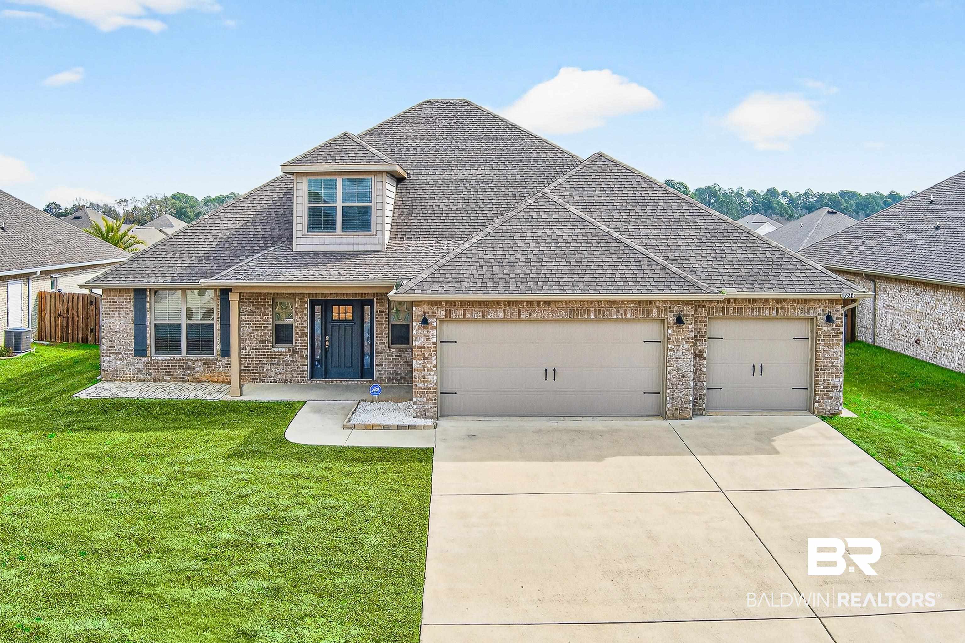 1728 Partridge Street Foley, AL 36535 - Photo 1 of 37 Brick facade residence featuring a multi-car garage, dormer window, covered entry, and concrete driveway