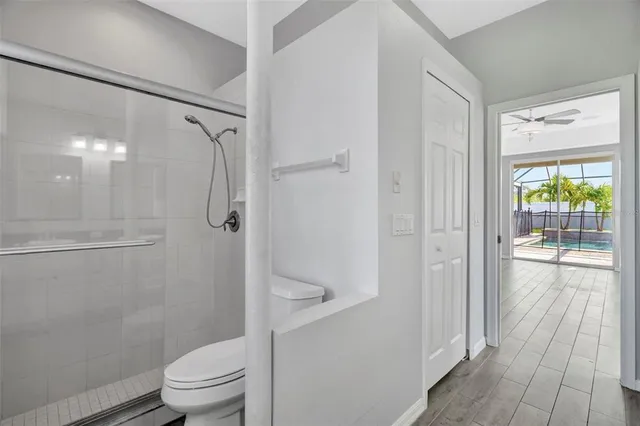 a bathroom with a granite countertop shower a toilet and a shower