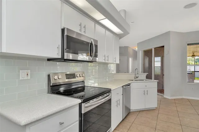 a kitchen with stainless steel appliances granite countertop a sink stove and microwave