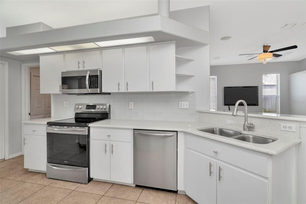 8918 Linebrook Drive Trinity, FL 34655 - Photo 9 of 50 a kitchen with white cabinets stainless steel appliances and sink