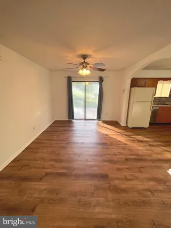 a view of a livingroom with wooden floor and a ceiling fan
