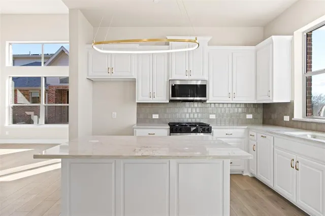 a kitchen with granite countertop white cabinets and a sink