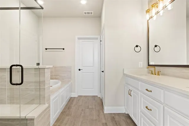 a bathroom with a granite countertop sink a mirror a vanity and a shower