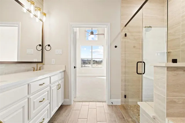 a bathroom with a double vanity sink a shower and a mirror