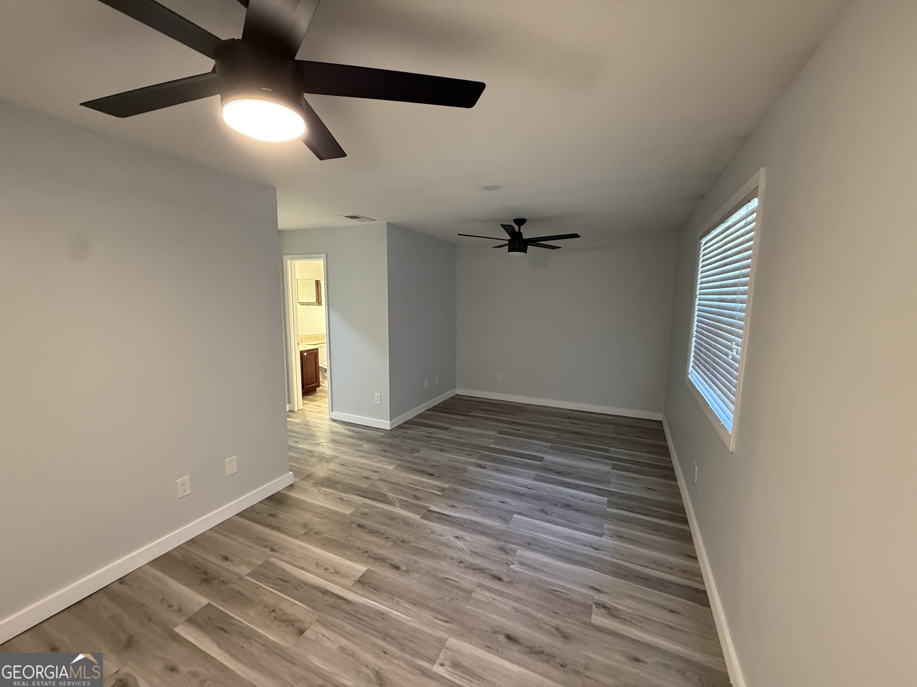 6900 Roswell Road, Unit K8 Sandy Springs, GA 30328 - Photo 15 of 30 a view of an empty room with wooden floor and a window